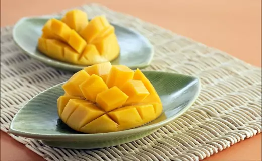 two plates have slice of mangoes